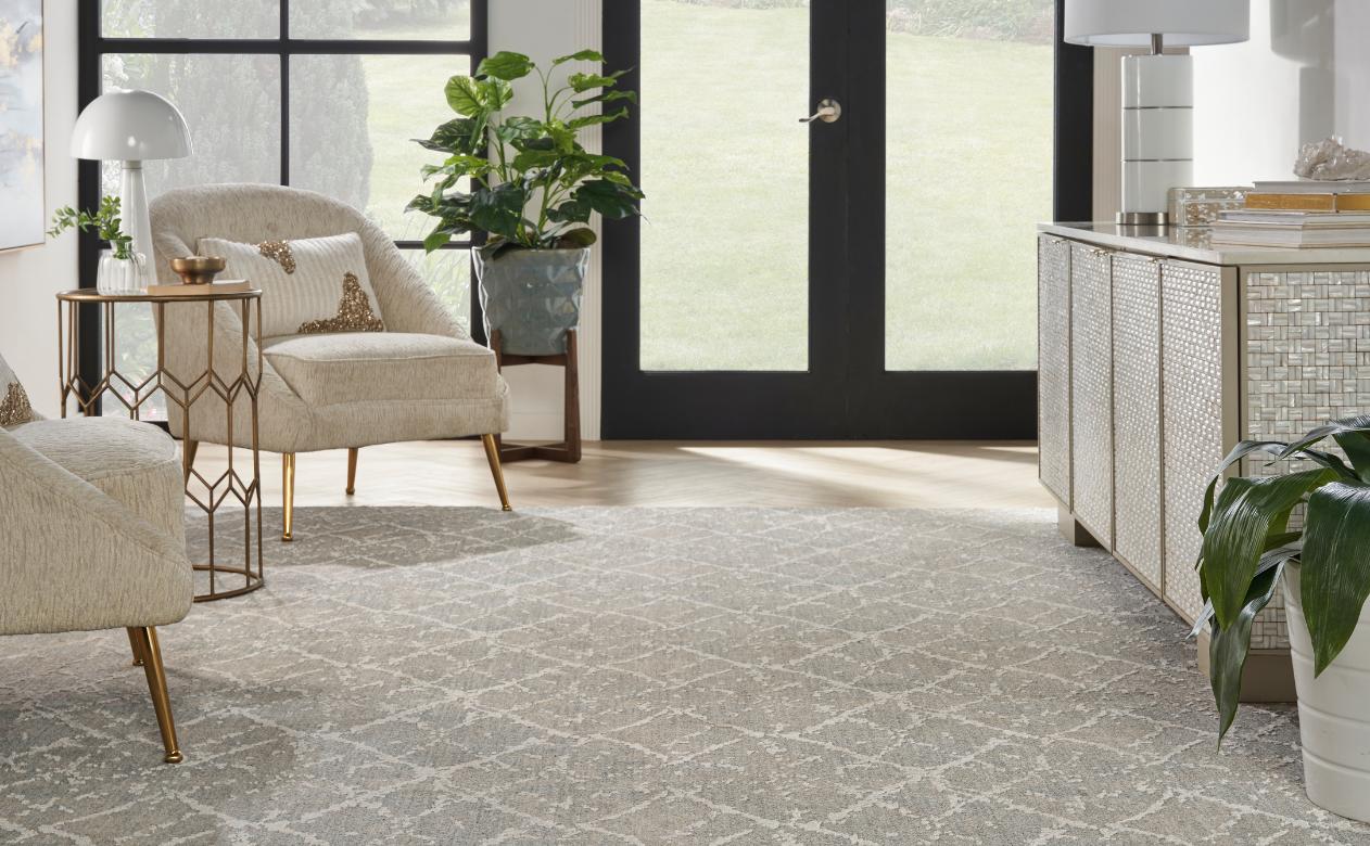 patterned grey carpet in living room with matching chairs and metal cabinet with mixed metal decor.